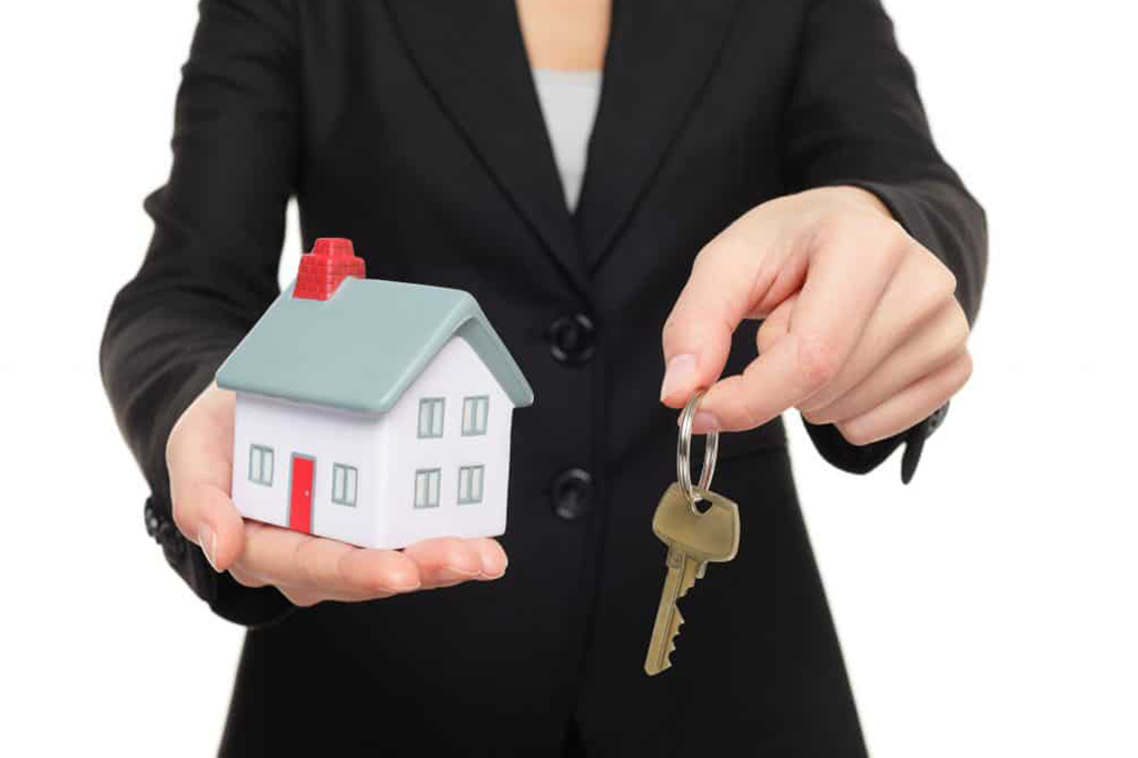 Woman holding keys and model house